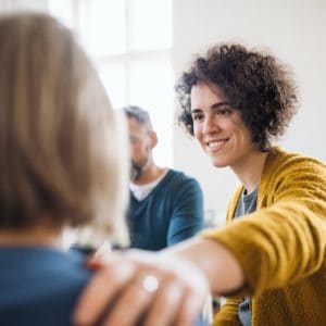 Men And Women Sitting In A Circle During Group Therapy, Supporting Each Other.